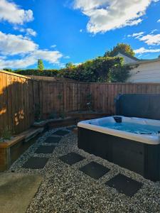 a hot tub in a backyard with a fence at The Old Tin Shed in Wanaka +2 photos