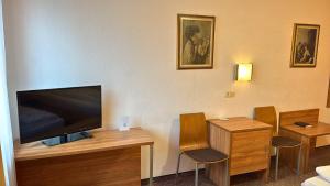 a room with a flat screen tv and two chairs at Hotel Relax in Wachenroth