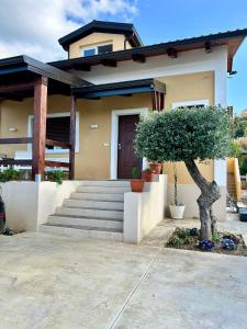 a house with a tree in front of it at Appartamento Costa degli Dei in Tropea