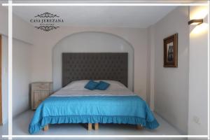 a bedroom with a large bed with a blue blanket at Casa Jerezana Hotel Boutique in Jerez de García Salinas