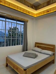 a bed in a room with a large window at Carpenters homestay in Sagada