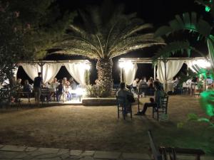 a group of people sitting in chairs in a park at night at Armonia by Grispos Villas in Schinoussa +251 photos