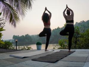 two women in a yoga pose by the water at Pont Bleu Suites - boutique hotel -Riverside & Pool in Canacona +101 photos