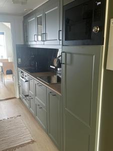 a kitchen with a refrigerator and a sink at Private Apartment Skudehaven in Rudkøbing