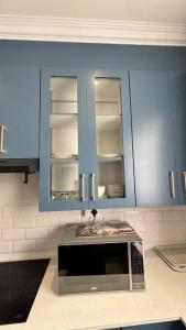 a kitchen with blue cabinets and a microwave at Two Sixty Nine in Gqeberha +98 photos