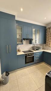 a kitchen with blue cabinets and a sink at Two Sixty Nine in Gqeberha