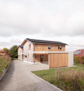 a wooden house with a black roof at Haus Kienzerleweg in Bad Kohlgrub