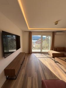 a living room with a couch and a large window at Villa Lungomare-Large Waterfront Apartment -Lungomare Promenade 6 in Cres