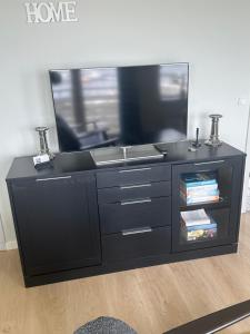 a black entertainment center with a flat screen tv at Private Apartment Skudehaven in Rudkøbing