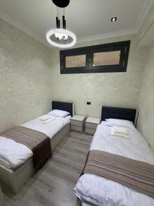 a bedroom with two beds and a chandelier at Guest house Пары Резиденты только с ЗАГСом in Samarkand