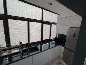 a kitchen with white cabinets and windows and a refrigerator at Guest house Пары Резиденты только с ЗАГСом in Samarkand +8 photos