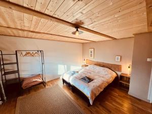 a bedroom with a bed and a wooden ceiling at Gîte Les sources proche Annecy in Vaulx