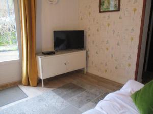 a living room with a tv on a dresser at La Source - 85 m2 & terrasse privée in Orcival +30 photos