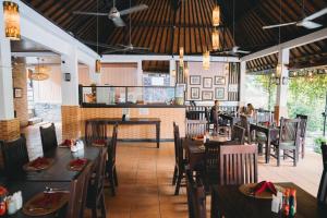 a restaurant with wooden tables and chairs and a counter at Liberty Dive Resort in Tulamben