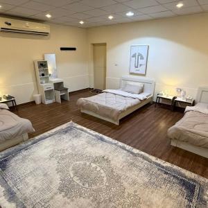 a large room with two beds and a rug at safeer farm in Qūr +22 photos