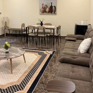 a living room with a couch and a table at safeer farm in Qūr