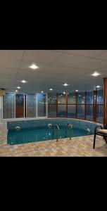 a large swimming pool in a large building with at safeer farm in Qūr