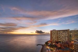 a view of a city and the ocean at sunset at Sheraton Waikiki Beach Resort in Honolulu +212 photos
