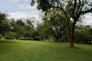 a park with green grass and trees and a building at Sheraton Kampala Hotel in Kampala