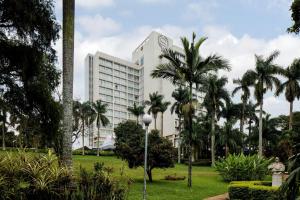 a large white building with palm trees in front of it at Sheraton Kampala Hotel in Kampala