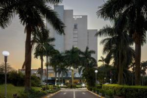 a building with palm trees in front of a street at Sheraton Kampala Hotel in Kampala +90 photos