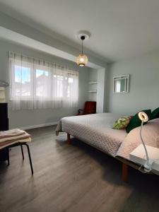 a bedroom with a large bed and a table at Piso en el centro de Viveiro in Viveiro