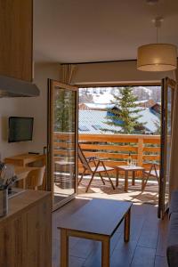 a kitchen with a sliding glass door leading to a patio at Résidence Arya - Living Stone in Vars