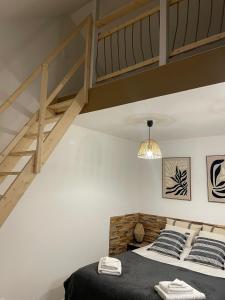 a bedroom with a loft bed and a staircase at House in forest proche GR and circuit in Saint-Mars-la-Brière
