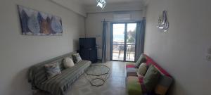 a living room with a couch and a table at Sunrise story in Artemida