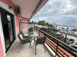 a patio with a table and chairs on a balcony at Sunrise story in Artemida