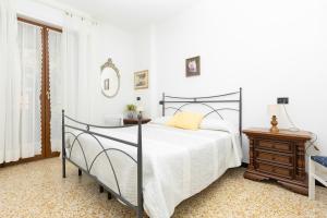 a white bedroom with a bed and a table at Apartment Vincenzina in Monterosso al Mare
