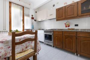 a kitchen with wooden cabinets and a table and a stove at Apartment Vincenzina in Monterosso al Mare +16 photos