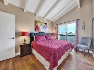 a bedroom with a large bed and a window at Oceanfront withIncredible Beach Views home in Newport Beach +10 photos