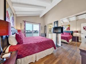 a bedroom with a large bed and a television at Oceanfront withIncredible Beach Views home in Newport Beach
