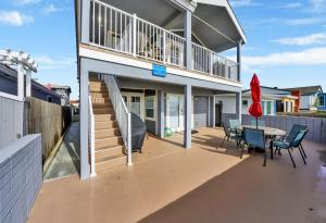 a house with a patio with a table and chairs at Value Beachfront withLarge Patio On The Bike Path apts in Newport Beach