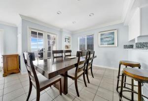 a dining room with a wooden table and chairs at Value Beachfront withLarge Patio On The Bike Path apts in Newport Beach