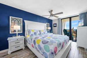 a bedroom with a bed and a blue wall at Phoenix II 2012 in Orange Beach