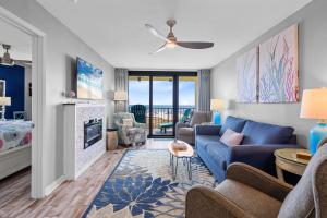 a living room with a blue couch and a fireplace at Phoenix II 2012 in Orange Beach