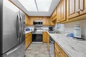 a kitchen with wooden cabinets and stainless steel appliances at Phoenix II 2012 in Orange Beach