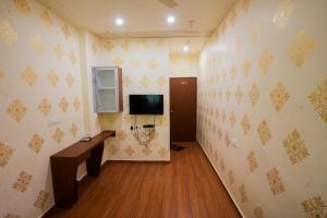 a room with a hallway with a tv on the wall at Hotel Tulsi in Nadiād