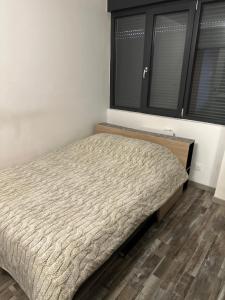 a bed in a bedroom with two windows at T1 studio in Farschviller +1 photo