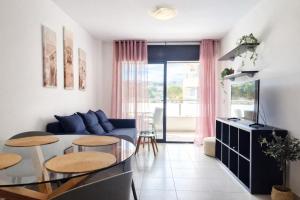 a living room with a blue couch and a glass table at Belice 1-6 in Lloret de Mar
