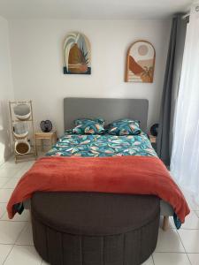 a bedroom with a bed with a red blanket at le Nid d Annie in Sancerre