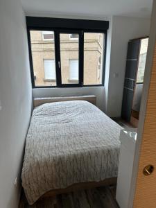 a bedroom with a bed and a large window at T1 studio in Farschviller