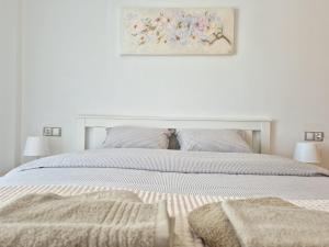 a white bedroom with a white bed with two pillows at Belice 1-6 in Lloret de Mar +14 photos