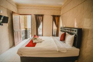 a bedroom with a large bed in a room at Santhi Graha Guest House in Legian