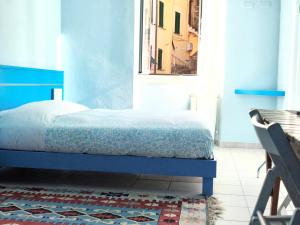 a bedroom with a blue bed and a window at Banchi Centrale in Riomaggiore