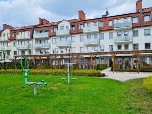 a large building with a green lawn in front of it at visit baltic - Kwartał Róży Wiatrów apartament SK30 z parkingiem in Świnoujście