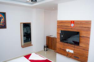 a living room with a flat screen tv on a wall at THE RAMA Executive in Tuljapur