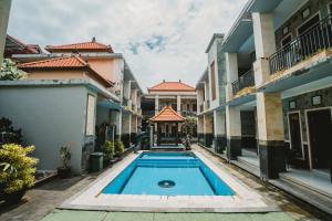 a swimming pool in a courtyard of a building at Santhi Graha Guest House in Legian +40 photos